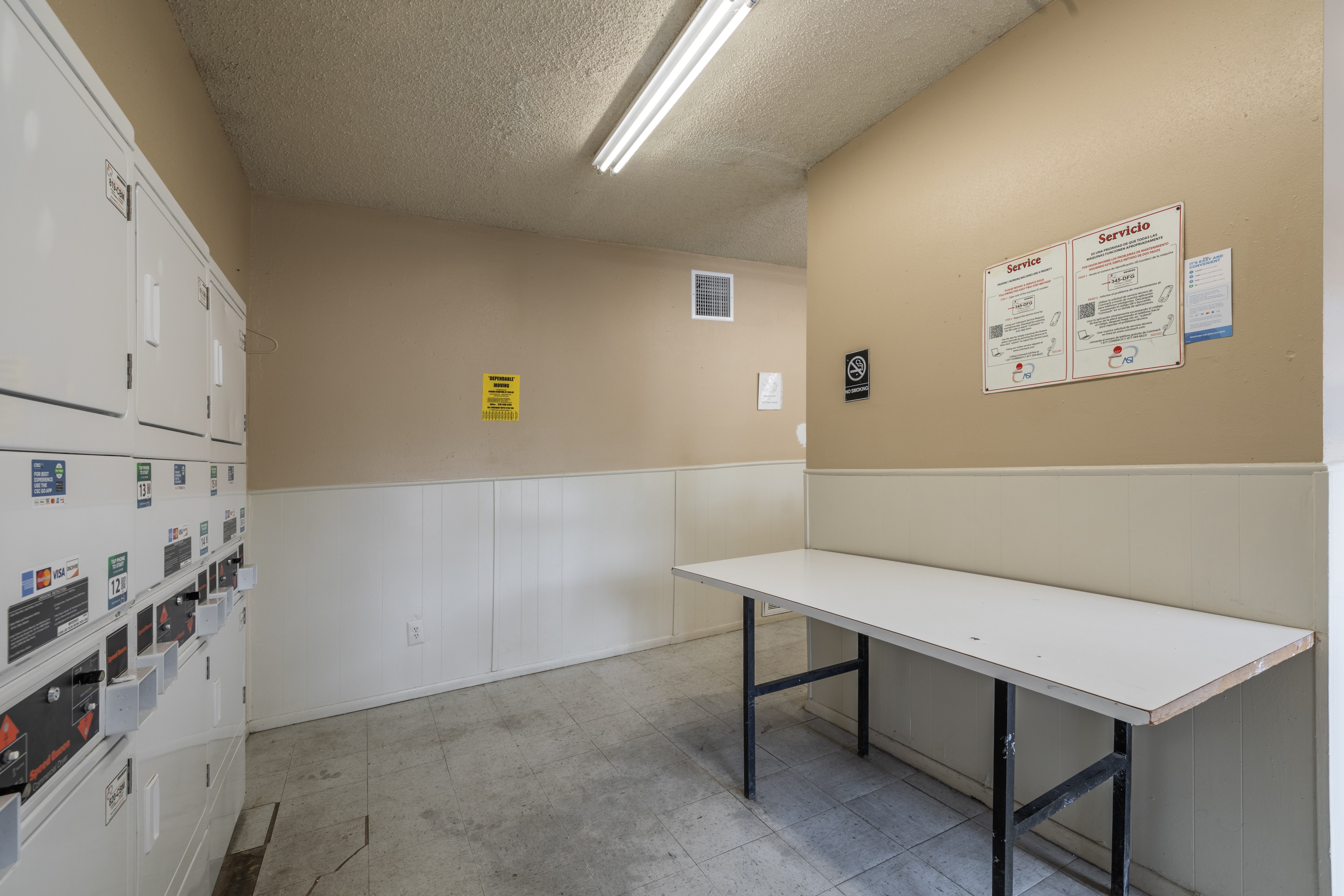 A room with a white table and a wall with a yellow sign on it.